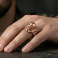 Load image into Gallery viewer, Rose gold plated gothic biker skull ring worn on finger, sculpted helmeted skull relief with beard detail, elegant lifestyle wear shot.