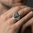 Load image into Gallery viewer, Oxidized sterling silver oni signet ring worn on the finger, close-up view showing the raised mask centerpiece