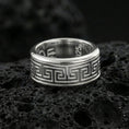 Load image into Gallery viewer, Polished silver Greek key wedding band on black volcanic stone, crisp geometric meander border detail, centered close-up studio lighting.