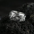 Load image into Gallery viewer, Polished silver nature-inspired roots band ring on black volcanic stone, crisp twisted vine relief with textured interior detail, centered close-up studio lighting.