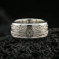Load image into Gallery viewer, Polished silver elven star fidget spinner ring on black volcanic stone, crisp intertwined knot pattern with central star detail, centered close-up studio lighting.