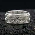 Load image into Gallery viewer, Polished silver Maltese cross fidget spinner ring on black volcanic stone, crisp cross relief with detailed scroll accents, centered close-up studio lighting.