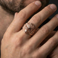 Load image into Gallery viewer, Rose gold plated finish masonic skull ring on a finger, macro lifestyle shot showcasing the gothic skull design, engraved shoulders, and bold signet profile