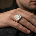 Load image into Gallery viewer, Sterling silver Armenian heraldic signet ring on the finger, macro lifestyle image emphasizing the polished silver finish and detailed eagle-lion coat of arms relief