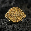 Load image into Gallery viewer, Sterling silver phoenix emblem signet ring with a gold plated finish, symbolic bird crest centerpiece and decorative side detailing, macro on volcanic rock