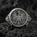 Load image into Gallery viewer, Sterling silver phoenix signet ring with an oxidized finish, round face engraved with a detailed heraldic phoenix motif, macro on black volcanic rock