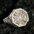 Load image into Gallery viewer, Sterling silver Maltese cross statement ring in a polished silver finish, bold octagonal signet design with engraved cross motif and textured background, close-up on volcanic stone