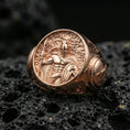 Load image into Gallery viewer, Sterling silver hoplite signet ring with a rose gold plated finish, round statement face with mythic warrior scene and engraved shoulder details, close-up on black volcanic rock