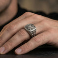 Load image into Gallery viewer, Sterling silver Lion of Judah signet ring worn on a finger, close-up lifestyle shot highlighting the oxidized square face and heraldic lion with cross motif