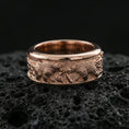Load image into Gallery viewer, Rose gold plated sterling silver bear relief band on volcanic stone, sculpted bear scene with deep contrast and ornate side details, minimal high-end close-up.