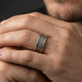 Load image into Gallery viewer, Oxidized sterling silver braided rope texture band worn on finger, woven pattern detail with beaded border accents, natural lifestyle hand shot with shallow depth of field.