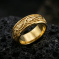 Load image into Gallery viewer, Gold plated dove pattern band ring on volcanic rock, detailed repeating bird motif with ornamental scrollwork, luxury jewelry product photography.