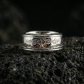 Load image into Gallery viewer, Polished silver Yggdrasil fidget spinner ring on black volcanic stone, crisp tree of life engraving with smooth comfort edges, centered close-up studio lighting.