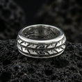 Load image into Gallery viewer, Polished silver arrowhead fidget spinner ring on black volcanic stone, crisp repeating arrow motif with smooth comfort edges, centered close-up studio lighting.