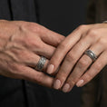 Load image into Gallery viewer, Oxidized sterling silver scrollwave spinner band worn on finger, flowing wave filigree detail on rotating center, natural lifestyle hand shot with shallow depth of field.