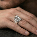 Load image into Gallery viewer, Sterling silver Egyptian monster mask ring on a finger, macro lifestyle image emphasizing the polished silver finish and sculptural pharaoh-style face design