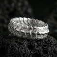 Load image into Gallery viewer, Polished silver gothic dragon scale band ring on black volcanic stone, crisp layered scale ridges with sculpted organic texture, centered close-up studio lighting.
