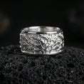 Load image into Gallery viewer, Polished silver flame swirl engraved band ring on black volcanic stone, crisp flowing fire relief with smooth comfort edges, centered close-up studio lighting.