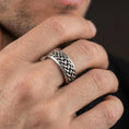 Load image into Gallery viewer, Oxidized sterling silver Celtic knot ring worn on finger, raised braid weave with dark recessed detailing, lifestyle hand close-up.
