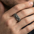 Load image into Gallery viewer, Oxidized sterling silver wolf and deer ring worn on finger, high-relief animal heads with dark recessed detailing, lifestyle hand close-up.
