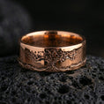 Load image into Gallery viewer, Rose gold plated Tree of Life engraved band on volcanic rock, soft warm highlights enhancing the organic branch-and-root details, luxury product shot.