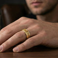 Load image into Gallery viewer, Gold plated floral scroll band ring worn on finger, warm shine accenting the engraved vine pattern for an elegant everyday style.