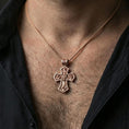 Load image into Gallery viewer, Holy Trinity cross pendant on the neck, back side visible in a lifestyle pose to highlight the second relief scene.