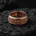 Load image into Gallery viewer, Fleur de lis band ring on volcanic stone with a rose gold plated look, showing the repeating motifs and smooth comfort-fit edges.