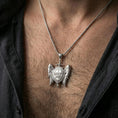 Load image into Gallery viewer, Polished silver winged protection pendant with Quis Ut Deus inscription worn on the neck in a close lifestyle frame, highlighting the detailed shield and feather texture