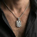 Load image into Gallery viewer, Polished silver Madonna pendant with infant Jesus worn on the neck in a close lifestyle frame, highlighting the crowned figure and detailed religious relief