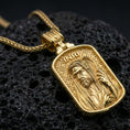 Load image into Gallery viewer, Gold plated Christian pendant with hooded Jesus figure, staff detail, and INRI lettering showcased on black volcanic rock in a refined macro jewelry image