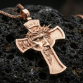 Load image into Gallery viewer, Rose gold plated crucifix pendant with crowned Jesus portrait, cross frame design, and engraved texture resting on volcanic rock in an elegant close-up product presentation