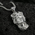 Load image into Gallery viewer, Polished silver Medusa head pendant necklace on textured volcanic rock, crisp close-up product shot highlighting the sculpted face and coiled serpent details.