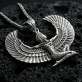 Load image into Gallery viewer, Oxidized winged goddess Isis pendant necklace on textured volcanic rock, centered close-up highlighting the spread wings, feather lines, and deep antique shadowed contrast.