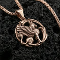 Load image into Gallery viewer, Rose gold plated griffin pendant necklace on textured volcanic rock, centered studio-style close-up showcasing soft rosy glow and intricate gryphon detailing throughout the design.