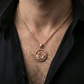 Load image into Gallery viewer, Rose gold plated Odin and raven medallion pendant necklace worn on the neck, lifestyle wear shot with elegant rosy shine and crisp warrior-and-raven engraving visible.