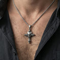 Load image into Gallery viewer, Oxidized gothic skull cross pendant worn on the neck in a lifestyle jewelry shot, styled against the chest for a bold and alternative statement look
