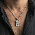 Load image into Gallery viewer, Polished silver Christian Jesus pendant with ascension relief worn on the neck in a close lifestyle frame, highlighting the sacred figure and detailed engraved background
