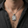 Load image into Gallery viewer, Polished silver Archangel Gabriel medallion with winged relief worn on the neck in a close lifestyle frame, highlighting the sacred portrait and detailed saint design