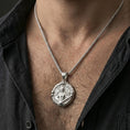 Load image into Gallery viewer, Polished silver Archangel Michael medallion with armored angel relief worn on the neck in a close lifestyle frame, highlighting the detailed wings, sword, and circular saint design