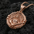 Load image into Gallery viewer, Rose gold plated Archangel Michael pendant with angel warrior portrait, round ornamental frame, and sacred inscription resting on volcanic rock in an elegant close-up product presentation