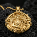 Load image into Gallery viewer, Rose gold plated Archangel Raphael pendant with angelic figure, healing emblem, and decorative round frame resting on volcanic rock in an elegant close-up product presentation