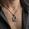 Load image into Gallery viewer, Oxidized Celtic raven knotwork pendant necklace worn on the neck, lifestyle framing showing realistic scale and bold vintage contrast against the chest.