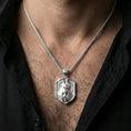 Load image into Gallery viewer, Polished silver Anubis pendant necklace worn on the neck, clean lifestyle wear shot capturing bright shine and the detailed jackal head relief in natural light.