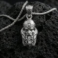 Load image into Gallery viewer, Polished silver Viking warrior head pendant necklace on textured volcanic rock, crisp macro product photo emphasizing clean edges, sharp facial sculpting, and bright reflective highlights on the helmet and beard.