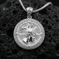 Load image into Gallery viewer, Polished silver Perseus coin pendant necklace on textured volcanic rock, crisp macro product photo emphasizing clean edges, sharp engraving, and bright reflective highlights on the portrait and border.