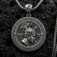 Load image into Gallery viewer, Oxidized Perseus coin pendant necklace on textured volcanic rock, centered close-up highlighting the Greek key border, winged helmet profile, and deep antique shadowed contrast.