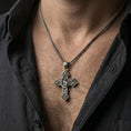 Load image into Gallery viewer, Oxidized Saint Michael cross pendant with winged archangel and shield worn on the neck in a lifestyle jewelry shot, styled against the chest for a bold and protective look