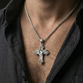 Load image into Gallery viewer, Polished silver Archangel Michael cross pendant with angel warrior relief worn on the neck in a close lifestyle frame, highlighting the ornate cross design and guardian symbolism