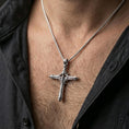 Load image into Gallery viewer, Polished silver gothic cross necklace with biomechanical detailing worn on the neck in a close lifestyle frame, highlighting the elongated silhouette and intricate structural relief